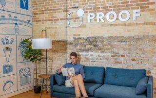 man sitting on blue sofa while reading book